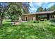 Home with a spacious backyard featuring a stone fire pit, lush lawn, and well-maintained landscaping at 4790 W Lakeridge Rd, Denver, CO 80219