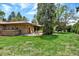 Expansive backyard with lush lawn, mature trees, and a patio area, offers a private outdoor retreat at 4790 W Lakeridge Rd, Denver, CO 80219