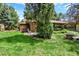 Secluded backyard of a home with mature trees, well-maintained lawn, and a stone patio area for outdoor living at 4790 W Lakeridge Rd, Denver, CO 80219