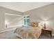 Cozy bedroom with paneled walls, plush bedding and backyard view at 4790 W Lakeridge Rd, Denver, CO 80219