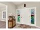 Charming foyer featuring a white door with decorative glass panels and a vintage cabinet at 4790 W Lakeridge Rd, Denver, CO 80219