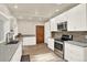 Well-lit kitchen features stainless steel appliances and an accent brick backsplash along the countertop at 4790 W Lakeridge Rd, Denver, CO 80219