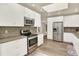 Spacious kitchen offers stainless steel appliances, white cabinets, brick backsplash, and wood-look flooring at 4790 W Lakeridge Rd, Denver, CO 80219