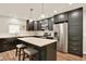 Kitchen with stainless steel appliances, island with seating, and dark cabinets for modern charm at 4790 W Lakeridge Rd, Denver, CO 80219