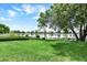 An expansive green lawn extends to the tranquil lake in this residence, reflecting the blue sky at 4790 W Lakeridge Rd, Denver, CO 80219