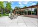 An outdoor patio with a table and chairs set offers space for gatherings and enjoying the lush backyard surroundings at 4790 W Lakeridge Rd, Denver, CO 80219