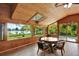 Bright sun room featuring wood-paneled walls and ceiling, large windows with scenic views, and a dining set at 4790 W Lakeridge Rd, Denver, CO 80219