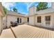 Wide backyard patio with a dining set, connecting the home and garage under a bright blue sky at 6929 E Briarwood Dr, Centennial, CO 80112