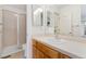 Bathroom featuring a vanity with wood cabinets, a sink, a mirror, and a shower with sliding glass doors at 6929 E Briarwood Dr, Centennial, CO 80112