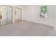 Spacious bedroom with plush carpet, sliding mirror closet doors, and a large window at 6929 E Briarwood Dr, Centennial, CO 80112