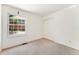 Bright bedroom with a closet, plush carpet, and a view of a brick home from the large window at 6929 E Briarwood Dr, Centennial, CO 80112