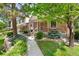 Charming brick home featuring a covered porch, beautiful landscaping, and mature trees in a desirable neighborhood at 6929 E Briarwood Dr, Centennial, CO 80112