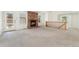 Bright living room with large windows, cozy brick fireplace and open access to the upstairs and kitchen at 6929 E Briarwood Dr, Centennial, CO 80112