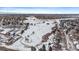 Winter aerial view showing a neighborhood of houses with golf course and snowy mountains in the background at 9875 Greensview Cir, Lone Tree, CO 80124