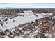 Aerial view of townhome community near golf course, snow-covered landscape and mountain views at 9875 Greensview Cir, Lone Tree, CO 80124