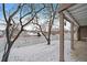 Backyard in winter showing a white picket fence, bare trees, and access to a covered patio area at 9875 Greensview Cir, Lone Tree, CO 80124