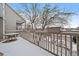 Balcony with view of the neighborhood in winter, complete with railing and an outdoor table at 9875 Greensview Cir, Lone Tree, CO 80124