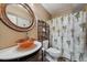 Bathroom featuring a vessel sink, ornate mirror, and tropical-themed shower curtain at 9875 Greensview Cir, Lone Tree, CO 80124