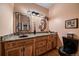 Bathroom with wood cabinets, granite countertop and an elegant mirror at 9875 Greensview Cir, Lone Tree, CO 80124