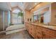 Elegant bathroom with a large soaking tub, double vanity, and granite countertops at 9875 Greensview Cir, Lone Tree, CO 80124