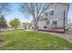 Spacious backyard with a lush lawn, mature tree, and a deck featuring outdoor dining set and BBQ at 11638 Xavier Way, Westminster, CO 80031
