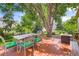 Outdoor living space with a dining table set on a wood deck under mature trees at 11638 Xavier Way, Westminster, CO 80031