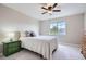Clean bedroom with a white bed, decorative pillows, and a bright window and green nightstand at 11638 Xavier Way, Westminster, CO 80031