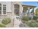 Close-up of front entrance with stone archway, wood door, and covered porch at 11638 Xavier Way, Westminster, CO 80031