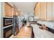 Spacious kitchen boasts stainless steel appliances, wood cabinets, and hardwood floors at 11638 Xavier Way, Westminster, CO 80031