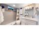 Modern basement bathroom with gray tile and white vanity at 7609 Sherman Pl, Denver, CO 80221