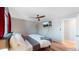 Main bedroom with hardwood floors, ceiling fan, and large TV at 7609 Sherman Pl, Denver, CO 80221