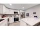 Modern kitchen with white cabinets and stainless steel appliances at 7609 Sherman Pl, Denver, CO 80221