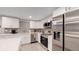 Modern kitchen with white cabinets, stainless steel appliances, and an island at 7609 Sherman Pl, Denver, CO 80221