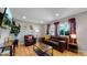 Spacious living room with hardwood floors, a leather couch, and large windows at 7609 Sherman Pl, Denver, CO 80221