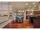 Open concept dining area featuring wood floors and modern lighting flowing into an island kitchen and comfortable living space at 26656 E Peakview Dr, Aurora, CO 80016