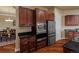 Gourmet kitchen features dark wood cabinetry, stainless steel appliances, and black granite countertops at 26656 E Peakview Dr, Aurora, CO 80016