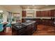Gourmet kitchen featuring dark wood cabinetry, stainless steel appliances, and a large center island with gas cooktop at 26656 E Peakview Dr, Aurora, CO 80016