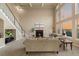 Elegant living room boasts a cozy fireplace, staircase, soaring ceilings, and expansive windows with picturesque views at 26656 E Peakview Dr, Aurora, CO 80016
