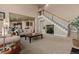 Spacious living room showcasing an open floor plan, staircase, neutral decor, and seamless flow to the kitchen and dining area at 26656 E Peakview Dr, Aurora, CO 80016