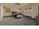 Large bedroom with a ceiling fan, several windows, and neutral walls with dark carpet at 26656 E Peakview Dr, Aurora, CO 80016