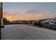 Spacious concrete patio with black metal fence showcasing neighborhood views and colorful sunset at 26656 E Peakview Dr, Aurora, CO 80016
