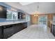 Bright kitchen with white tile floors, dark cabinets, and views of the natural surroundings at 27857 Apex Cir, Evergreen, CO 80439