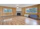 Spacious living room featuring wood-look floors, a fireplace, and natural light from large windows at 27857 Apex Cir, Evergreen, CO 80439
