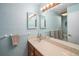 Bathroom featuring a long vanity, sink, and a large mirror with vanity lights above at 1482 S Lansing St, Aurora, CO 80012