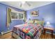 Bright bedroom with hardwood floors, light-blue walls, and a window with green curtains at 1482 S Lansing St, Aurora, CO 80012