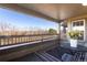 Relax on this covered balcony with a table, chairs, and views of the neighborhood landscape at 12762 Ironstone Way # 302, Parker, CO 80134