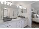 Bathroom features a marble countertop with double vessel sinks, and white cabinetry at 12762 Ironstone Way # 302, Parker, CO 80134