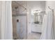 Bright bathroom featuring white marble tile, a glass enclosed shower, and a modern vanity with white cabinets at 12762 Ironstone Way # 302, Parker, CO 80134