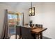 Inviting dining area with wood table, modern light fixture, and access to a private balcony with views at 12762 Ironstone Way # 302, Parker, CO 80134