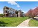 Well-maintained building exterior with beautiful landscaping, lush lawn and flowering tree at 12762 Ironstone Way # 302, Parker, CO 80134